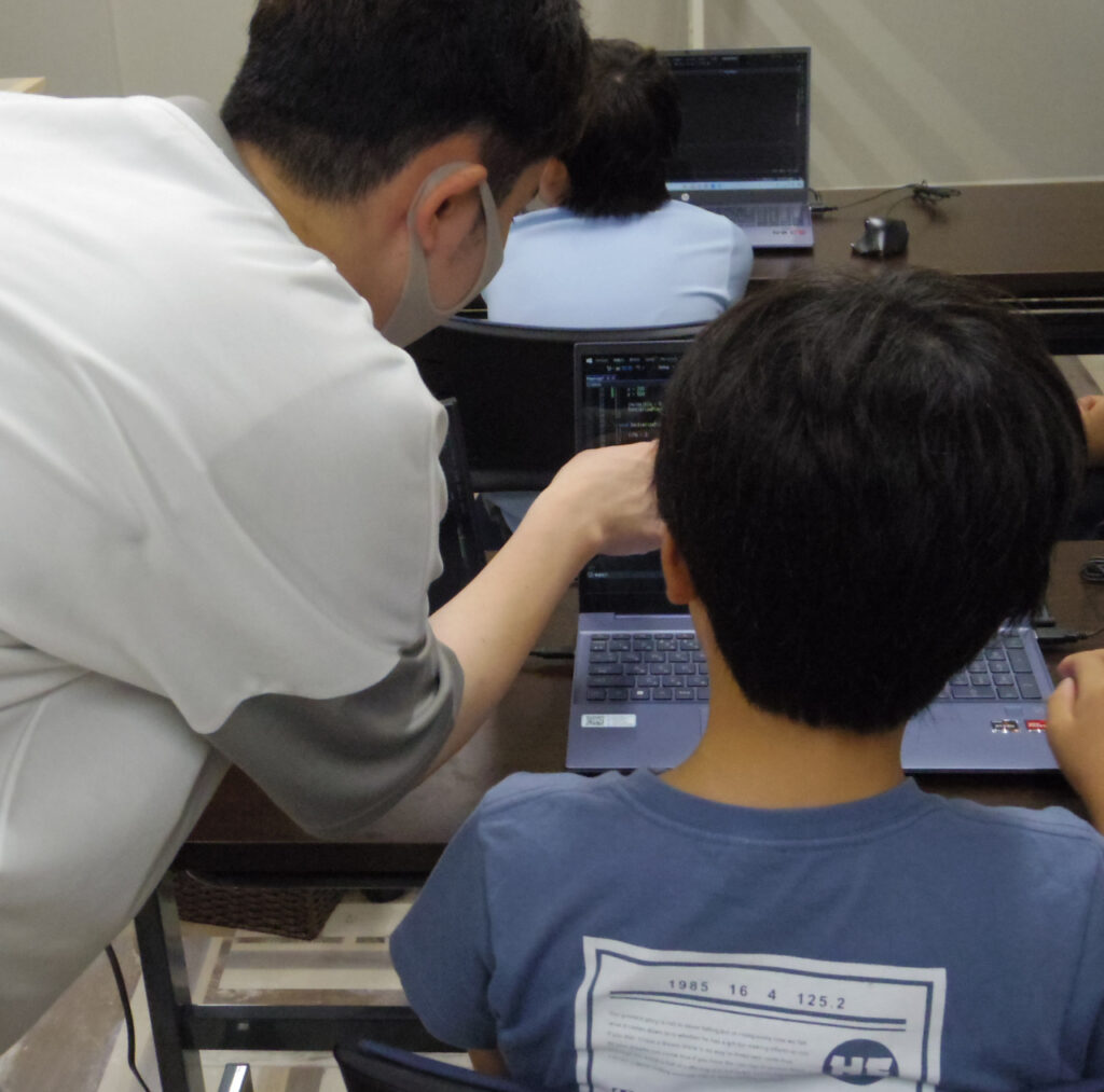 プログラミングを教える講師と生徒