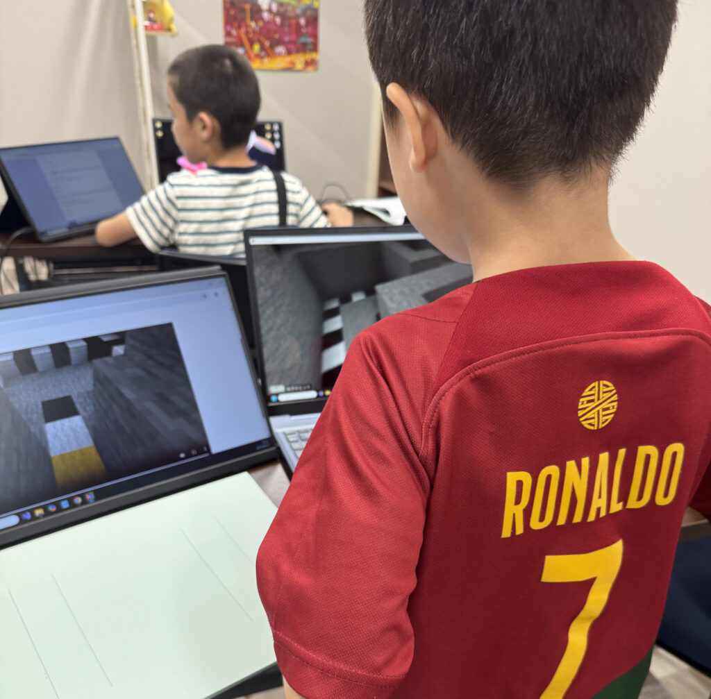 夢中でマイクラプログラミングをする子供達